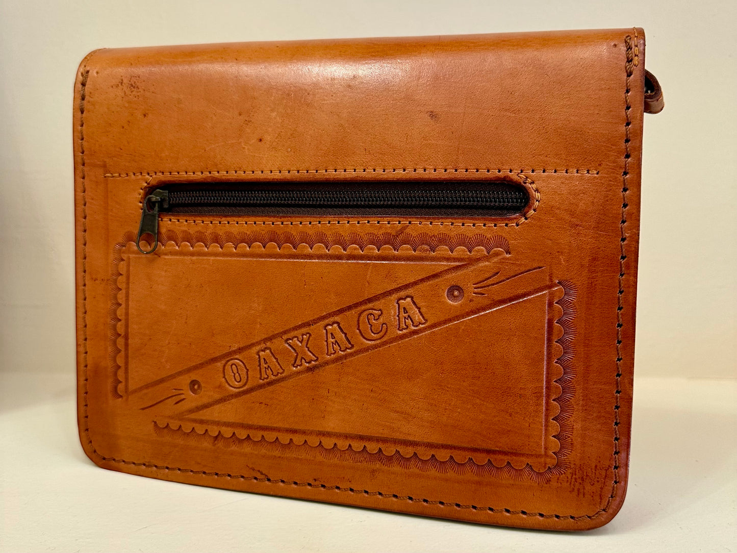 Bolso tipo clutch de cuero cruzado cincelado a mano