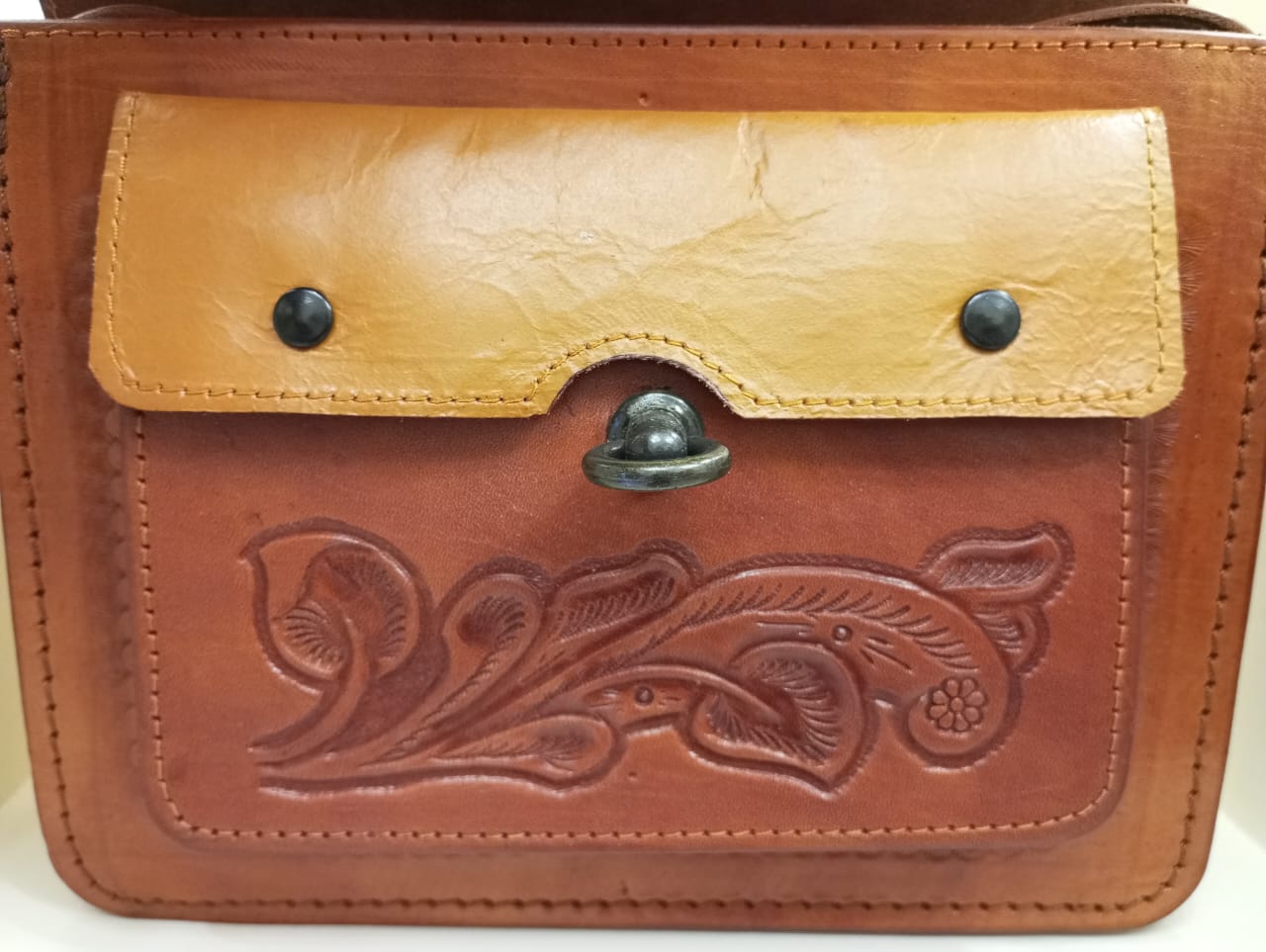 Bolso tipo clutch de cuero cruzado cincelado a mano