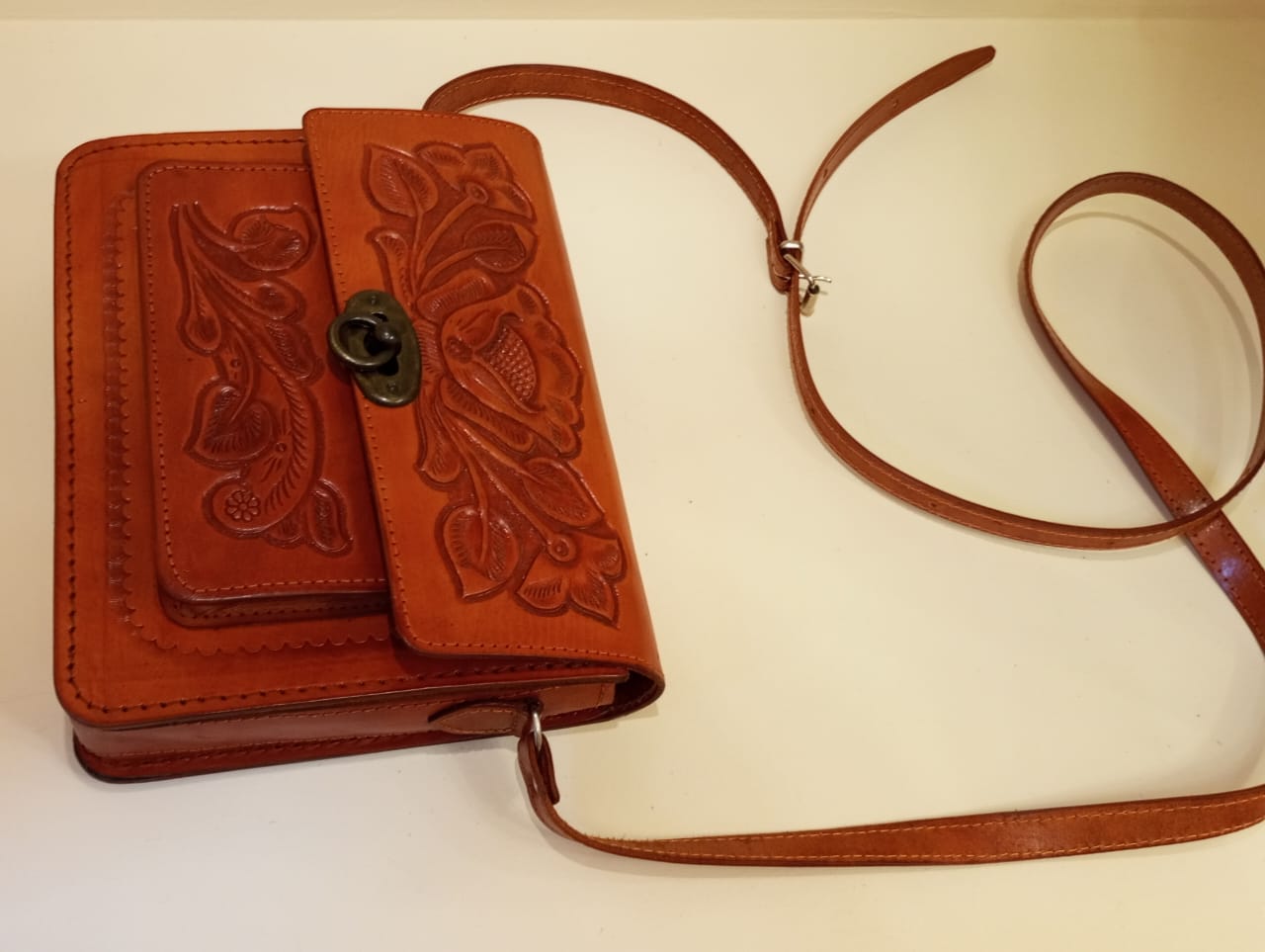 Bolso tipo clutch de cuero cruzado cincelado a mano